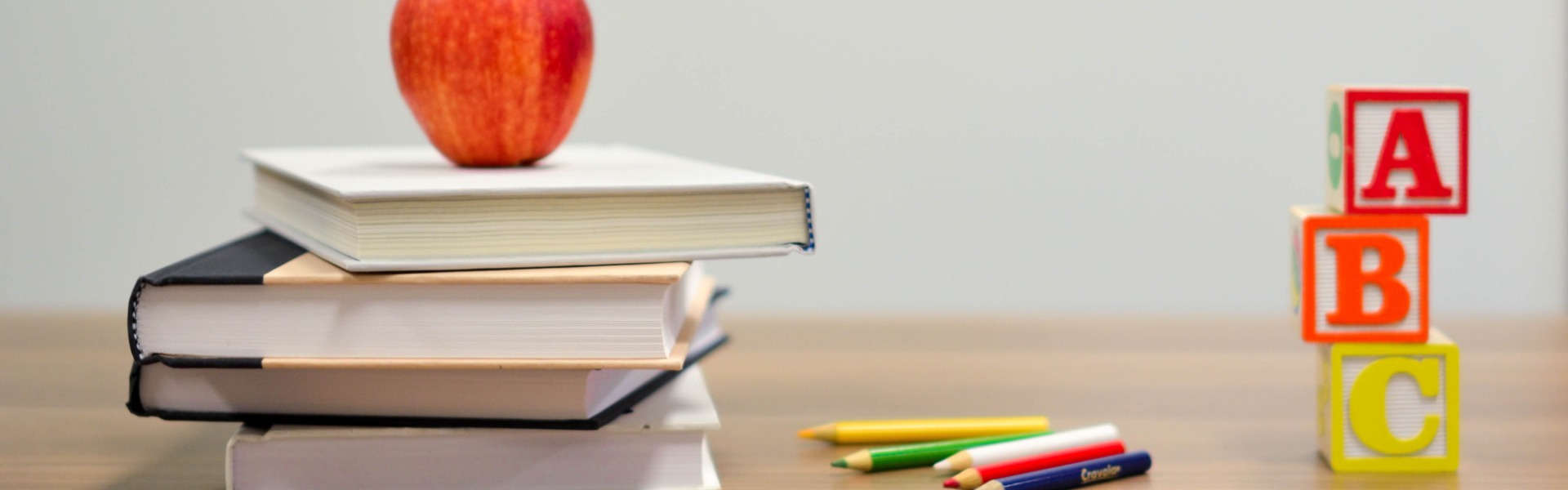 Picture of an apple and books on a desk